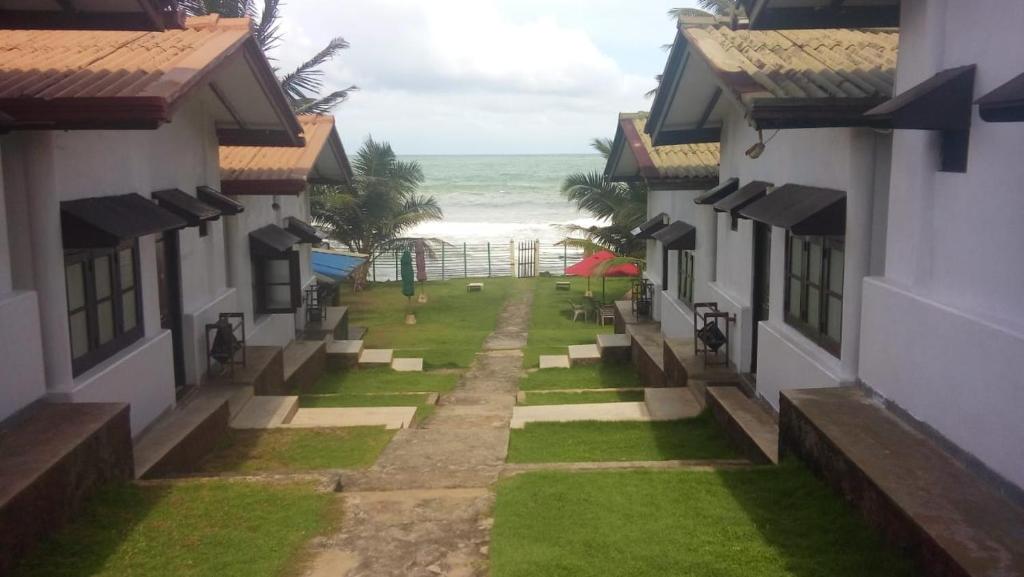安伯朗戈德Ramon beach resort的两栋房屋之间享有海滩美景