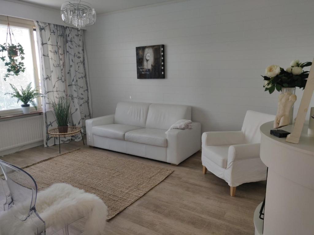 波里Yyterin valkoinen huoneisto 14A talo B 21的客厅配有白色的沙发和椅子