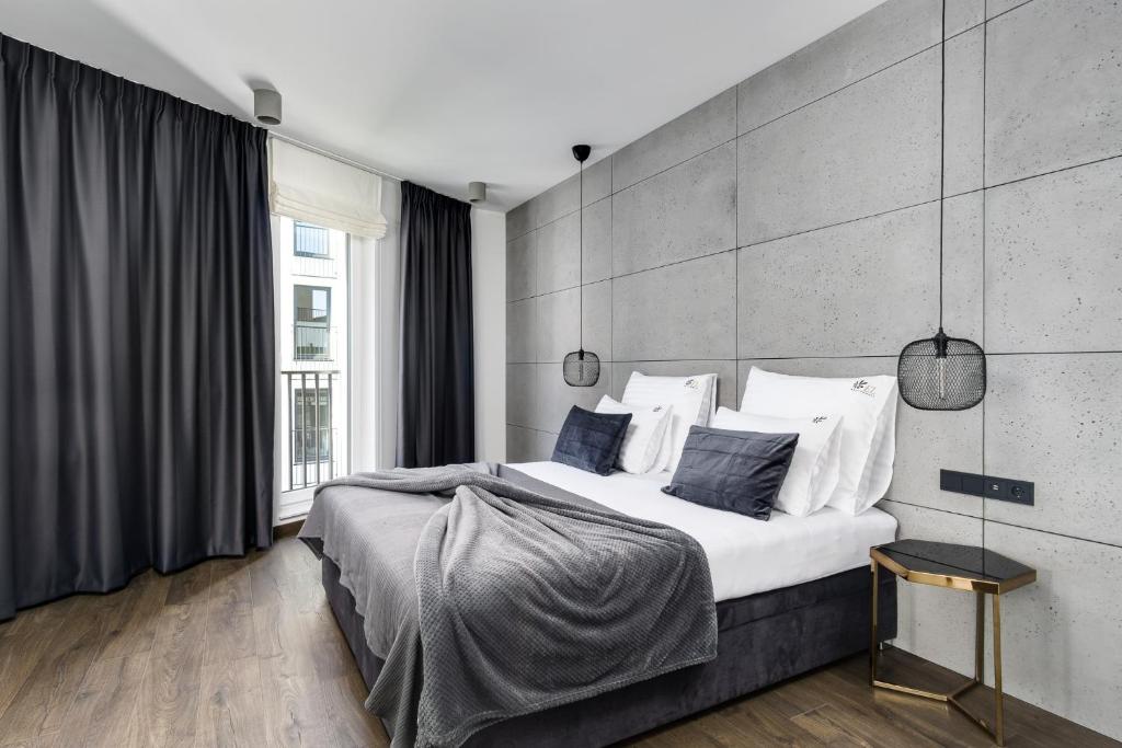 波兹南EL Apartments - Hercules的卧室配有一张带白色床单和枕头的大床。