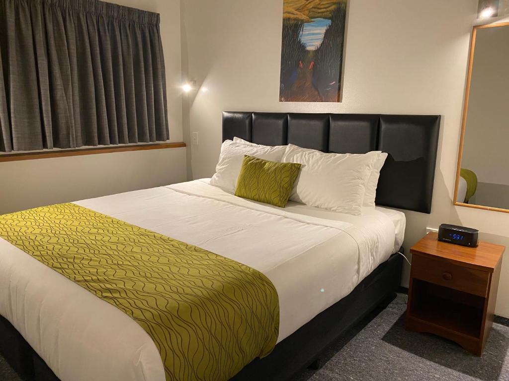 因弗卡吉尔阿舒尔城市人汽车旅馆的一间卧室配有一张大床和黑色床头板