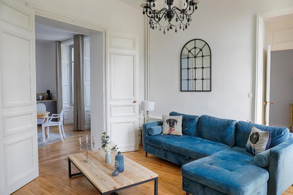 欧赖Résidence L'Aristide Appartement Louison的客厅配有蓝色的沙发和桌子