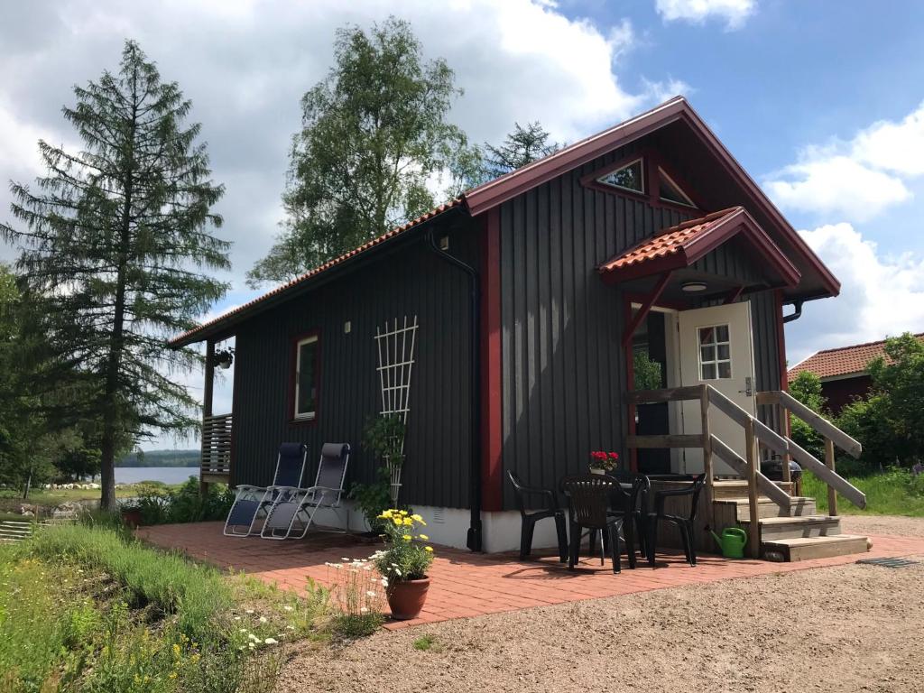 KalvJoarsbo, Stuga 2, Gårdsstugan的黑色小屋 - 带甲板和椅子