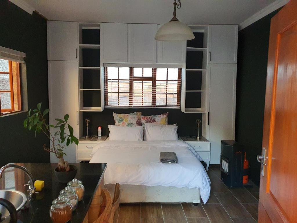 约翰内斯堡Melvilla Studio的卧室配有白色的床和桌子