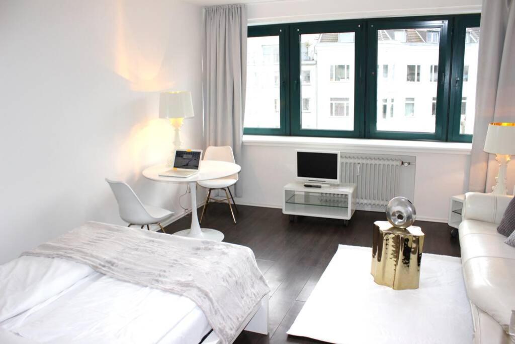 科隆a-partment • Köln- Mediapark的一间卧室配有一张床、一张桌子和一张沙发