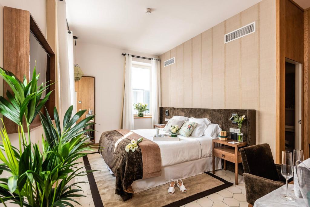 马翁Boutique Hotel Sant Roc & Spa的酒店客房配有一张床铺和一张桌子。