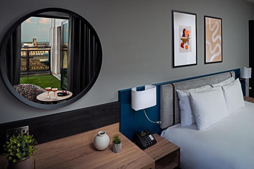 利默里克乔治利默里克酒店的一间卧室配有一张床、镜子和一张桌子