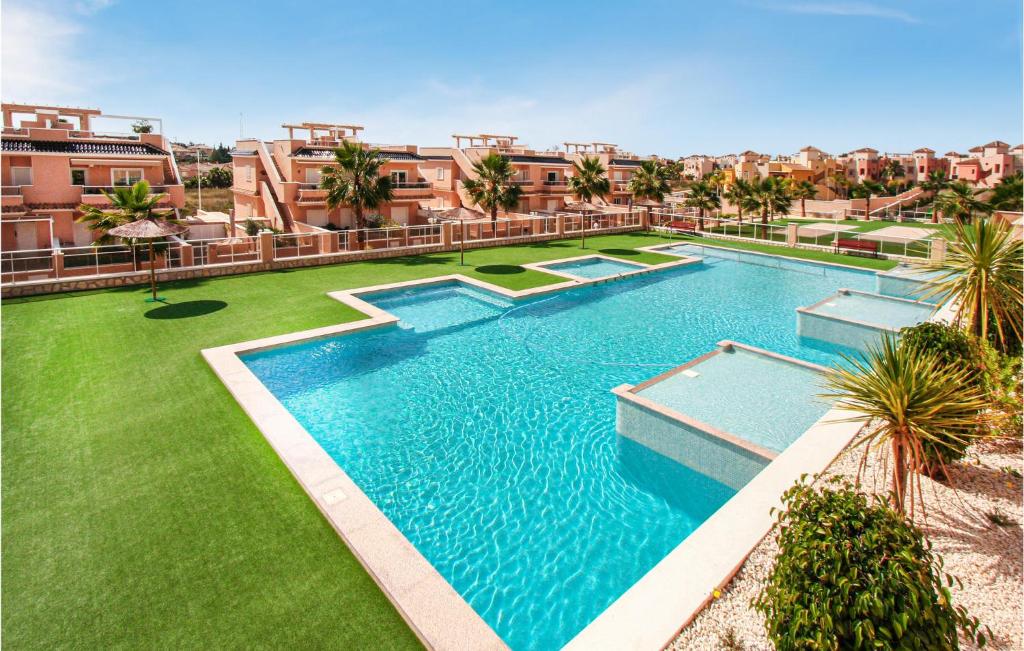 蓬塔普里马2 Bedroom Gorgeous Apartment In Torrevieja的享有棕榈树和建筑的游泳池的顶部景致