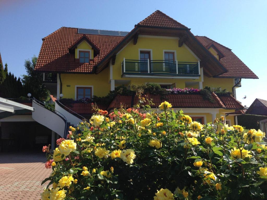 Wenigzell豪斯玫瑰宾馆的前面有鲜花的黄色房子