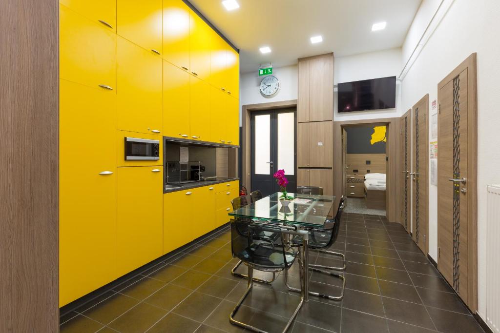 布达佩斯E14设计旅馆 的厨房配有黄色橱柜和玻璃桌
