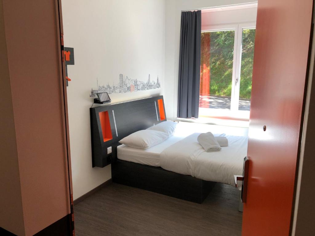 苏黎世easyHotel Zürich West的一间小卧室,配有床和窗户