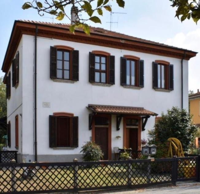 卡普里亚泰圣杰尔瓦肖Crespi d'Adda a "colori"的白色的房子,设有棕色的窗户和栅栏