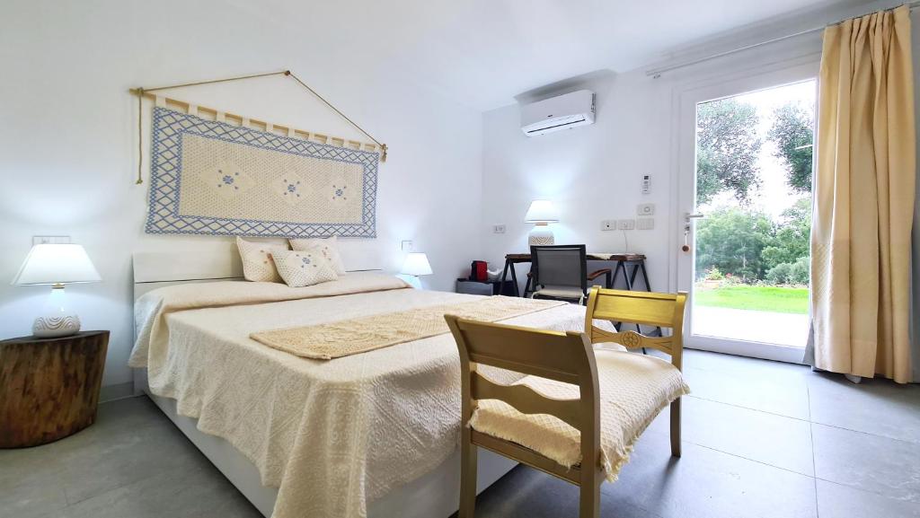奥尔比亚Sole Matto Rooms的卧室配有床、椅子和窗户。