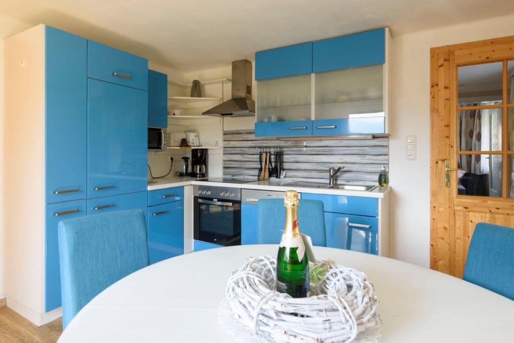 帕斯格许特路旁鲁斯巴赫特林德公寓的蓝色的厨房,桌子上放着一瓶葡萄酒