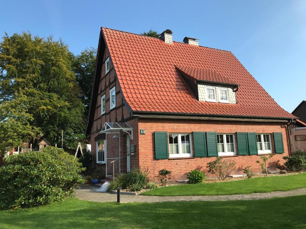 埃舍德Ferienhaus-Eschede的红屋顶砖屋和院子