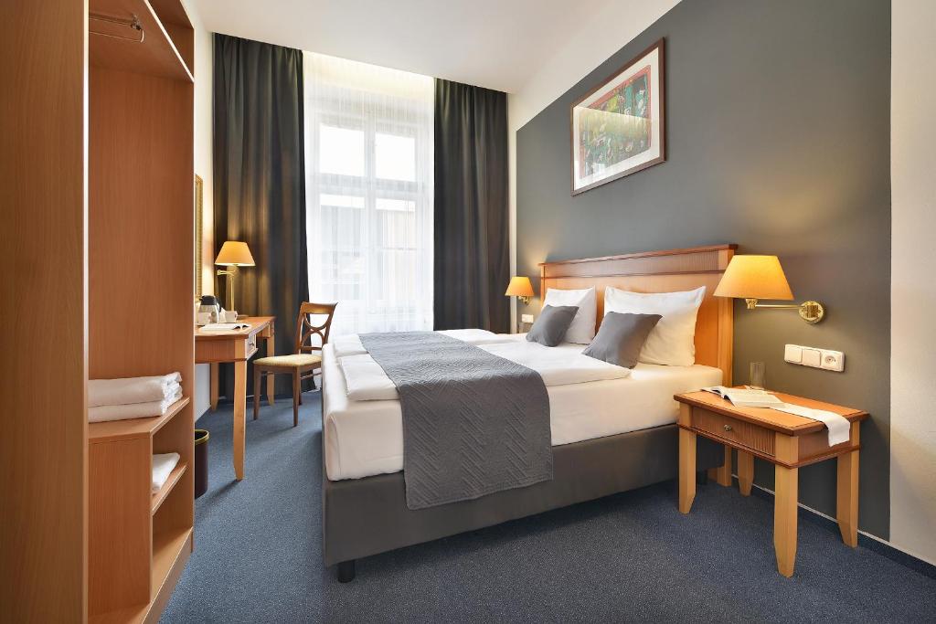 布拉格Prague Season Hotel的配有一张床和一张书桌的酒店客房