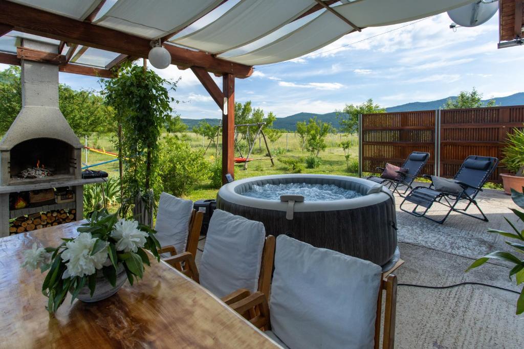 SinacHoliday Home Sinac的庭院设有热水浴池、桌子和椅子。