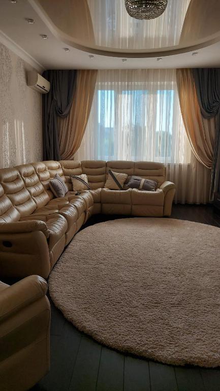基辅Просторные апартаменты的客厅里一张大皮沙发,有大地毯