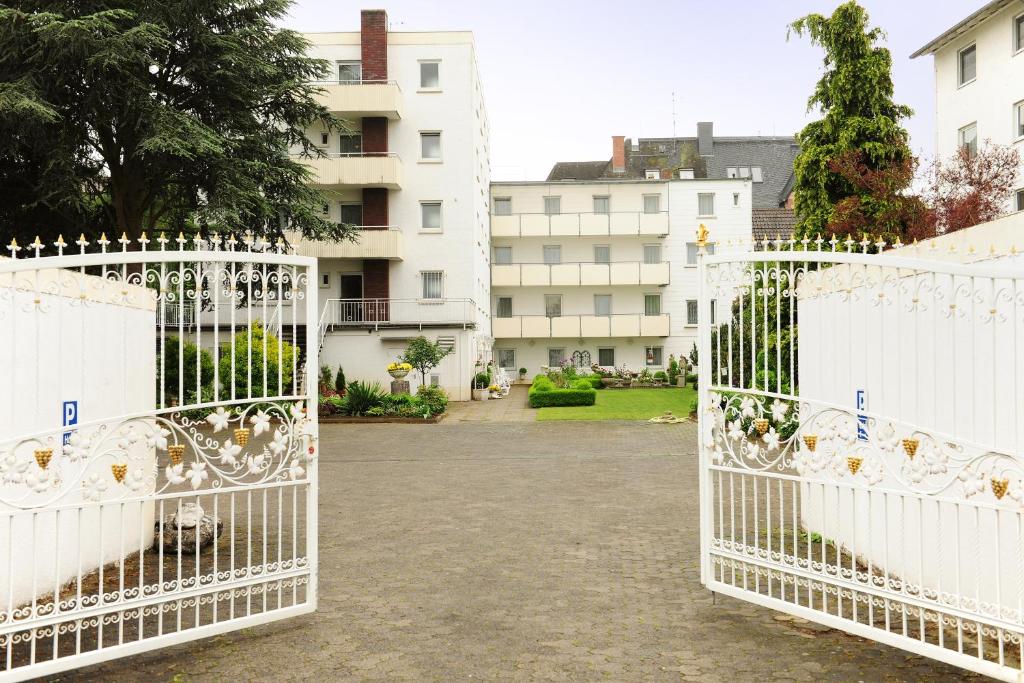 金斯海姆-古斯塔夫斯堡阿尔特波斯特卡尼酒店的两扇白色的大门,位于一座带建筑物的庭院内