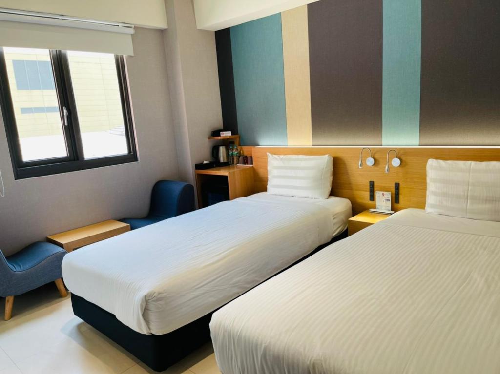屏东县富光商旅的酒店客房,配有两张床和椅子