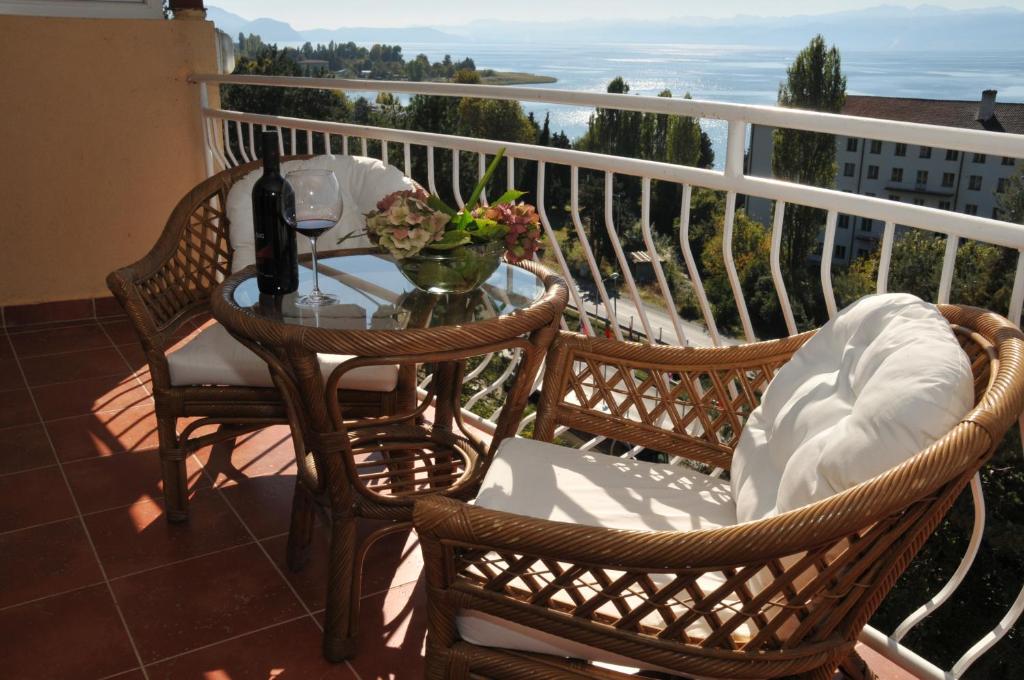 奥赫里德贝尔福德雷尔酒店的阳台配有两把椅子和一张桌子及一瓶葡萄酒