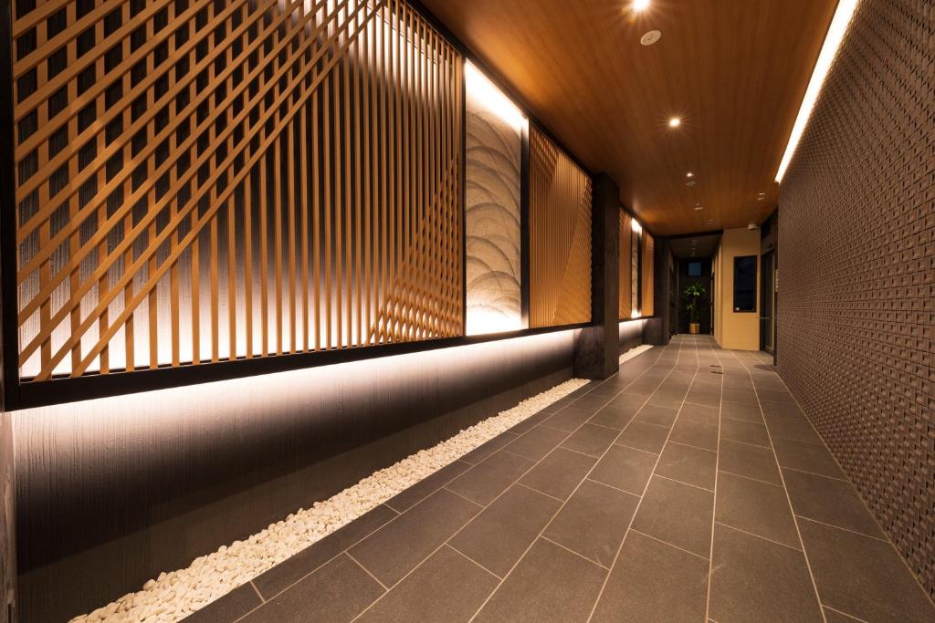 大阪Shirakabanoyado - EBISU的建筑的走廊,有墙和瓷砖地板
