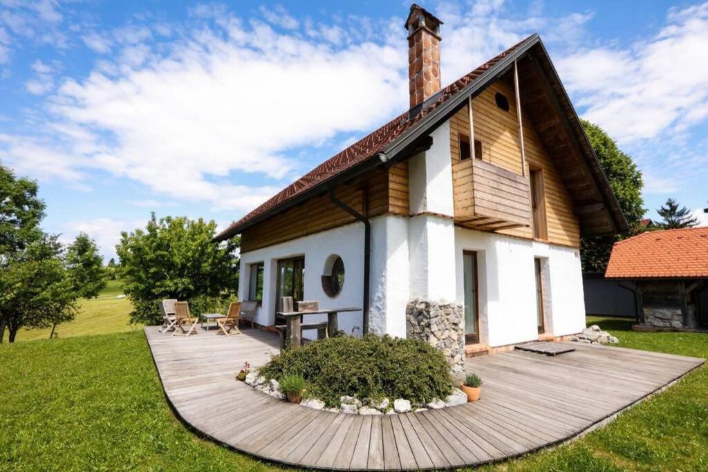 HotedršicaUnique Cottage House With Panoramic View On Ravnik的庭院中带木甲板的房子