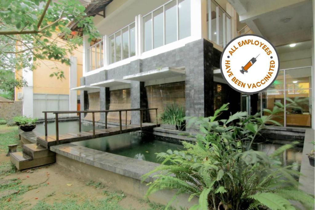 KalasanUniversity Hotel的一座带游泳池的建筑前的标志