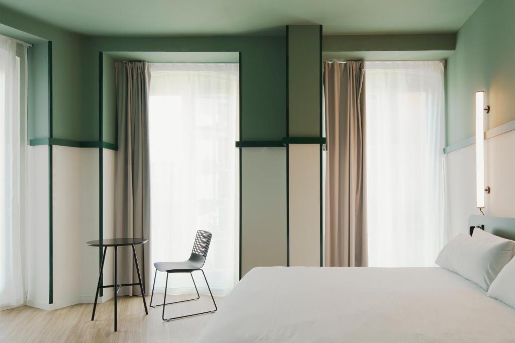 马德里B&B HOTEL Madrid Centro Plaza Mayor的卧室配有白色的床和椅子