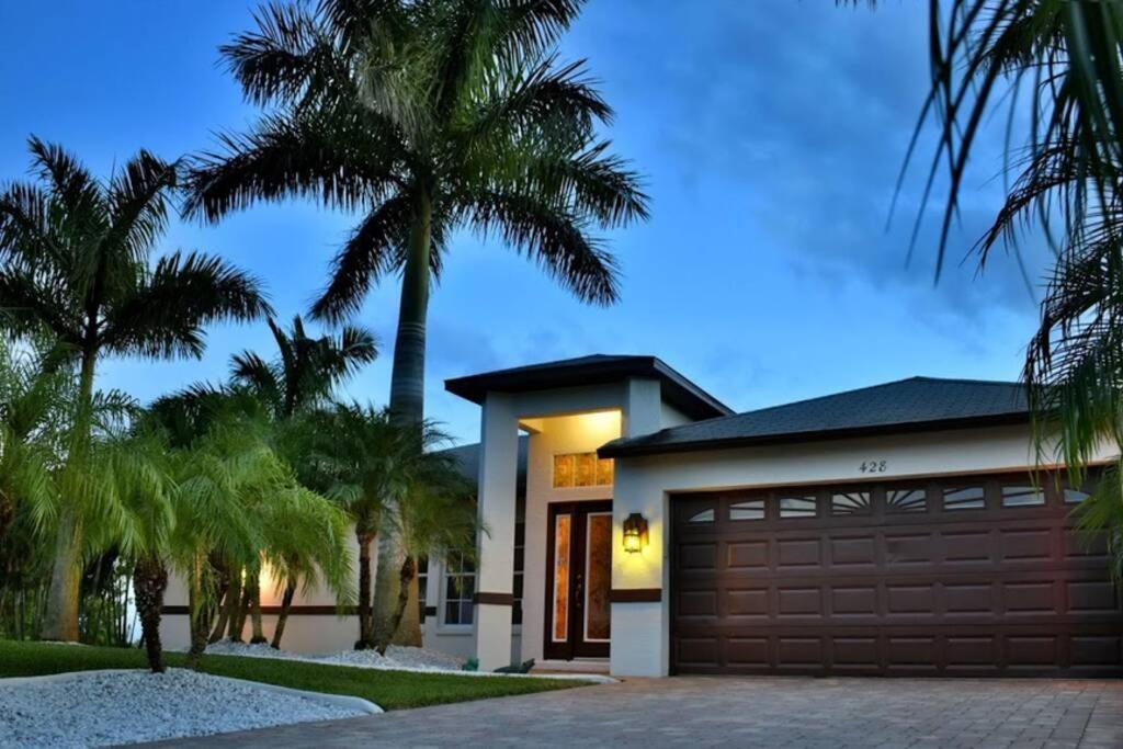 珊瑚角Villa Florida Vacation的一座带车库和棕榈树的房子