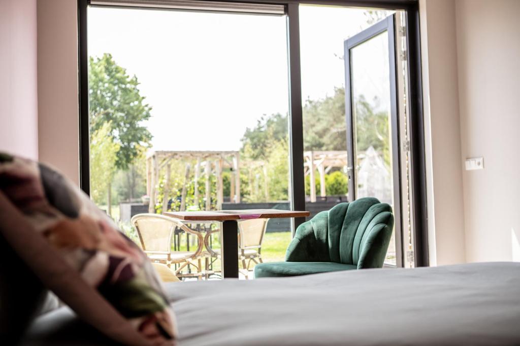 BlesdijkeNatuur lodge的一间卧室配有一张床,享有庭院的景色