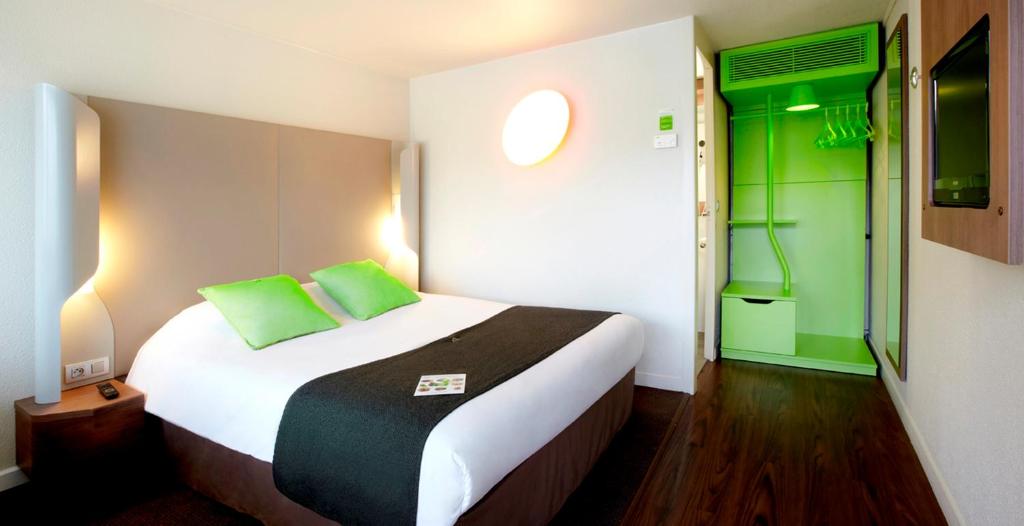 比亚里茨钟楼比亚丽兹酒店的一间卧室配有一张绿色的大床