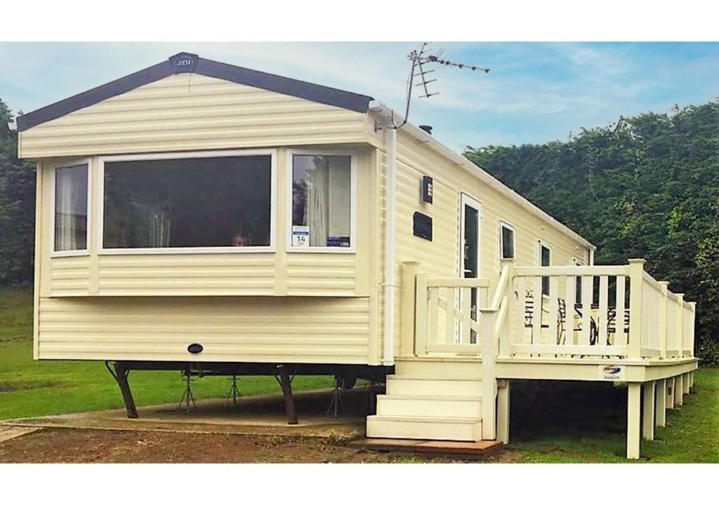 尚克林Isle of Wight Caravan的一座白色的小房子,设有门廊