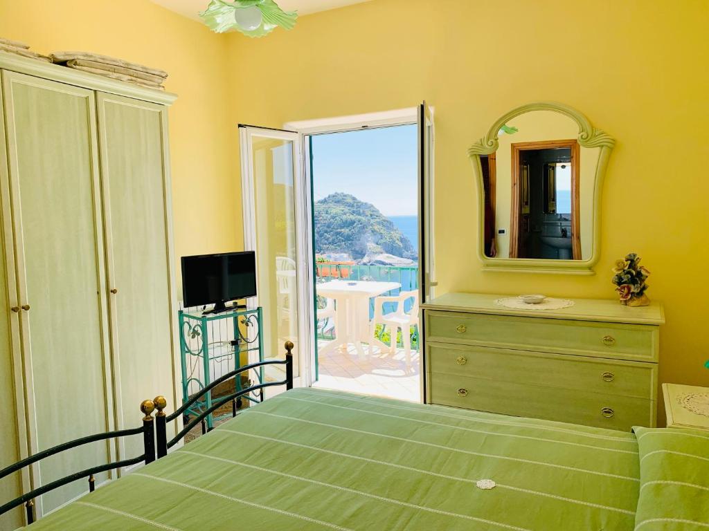 伊斯基亚Pensione Casa Verde的一间卧室配有一张带梳妆台和镜子的床