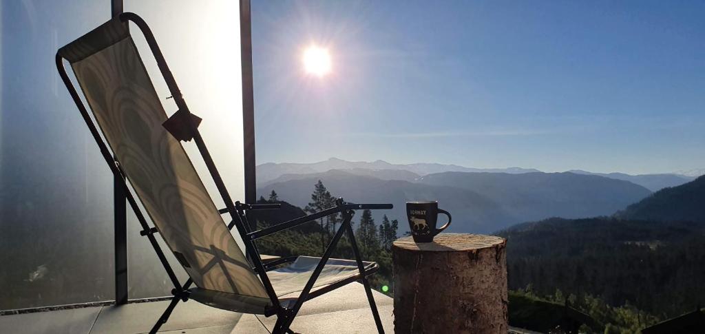 GiljaneTiny mountain cabin with a panoramic view的坐于树 ⁇ 上的椅子,享有山景