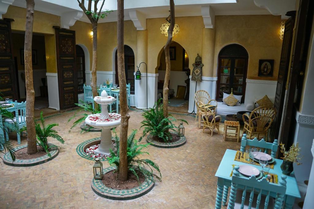 马拉喀什Riad Dama & Spa的配有桌椅和棕榈树的客房
