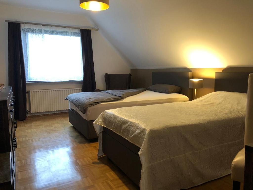诺伊斯Privatunterkunft "An der Hecke"的一间卧室设有两张床和窗户。