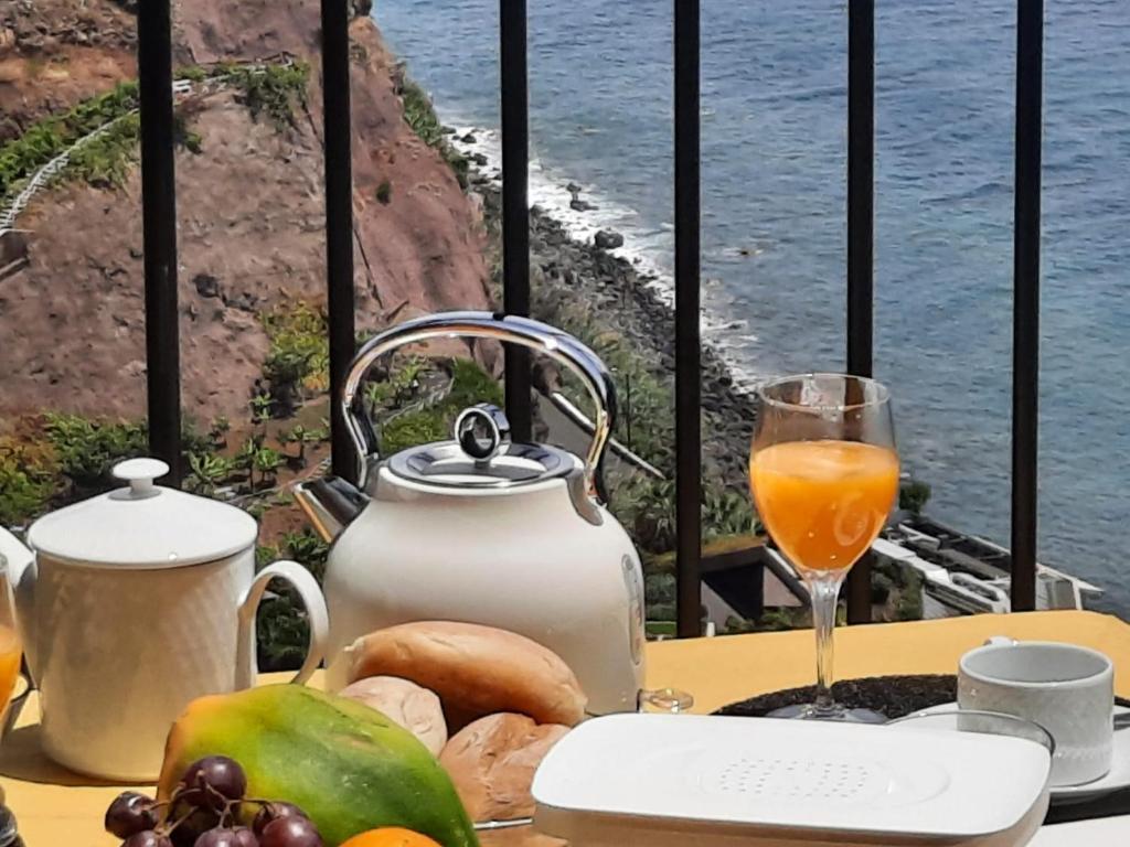 卡列塔Zeza´s Sky的一张桌子,上面放着食物和一杯橙汁