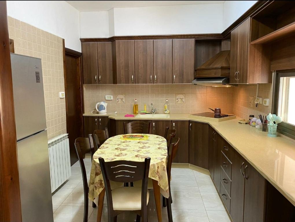 伯利恒Joseph apartment的厨房配有桌椅和冰箱。