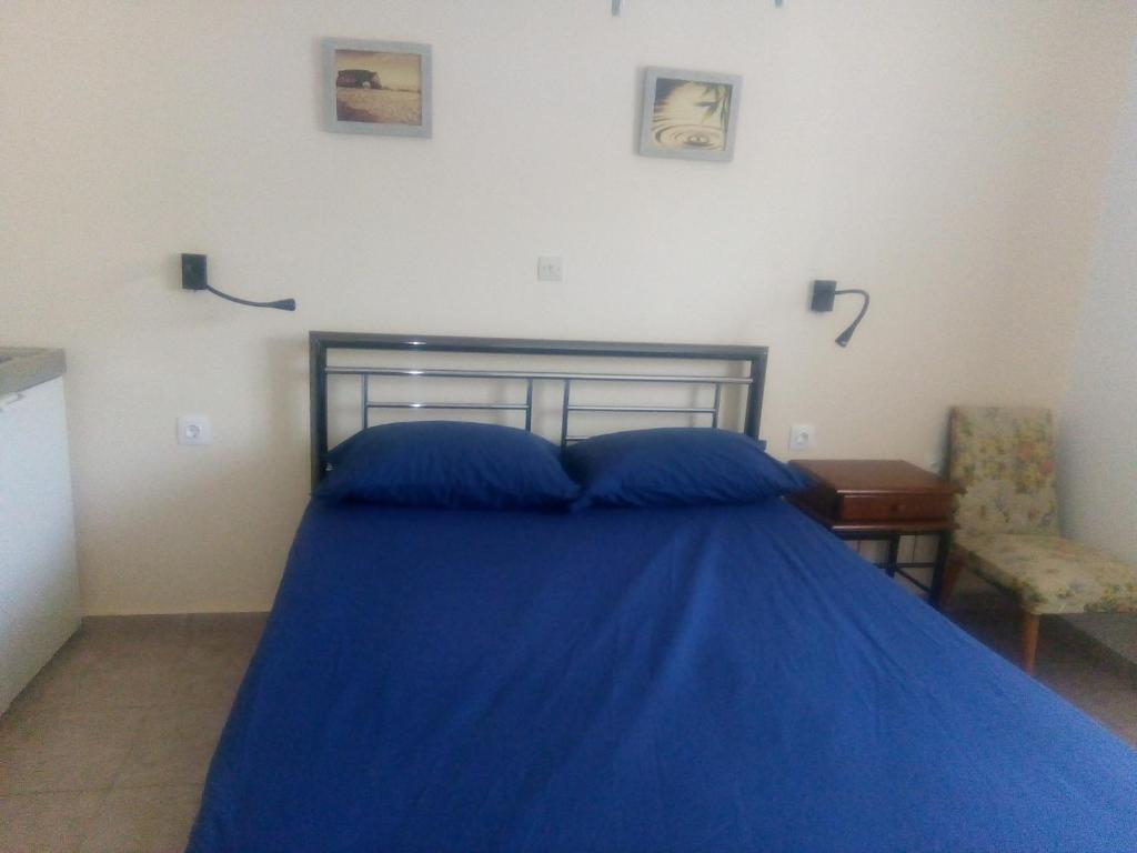阿波罗Balcony to Aegeon 3的一间卧室配有蓝色的床和椅子