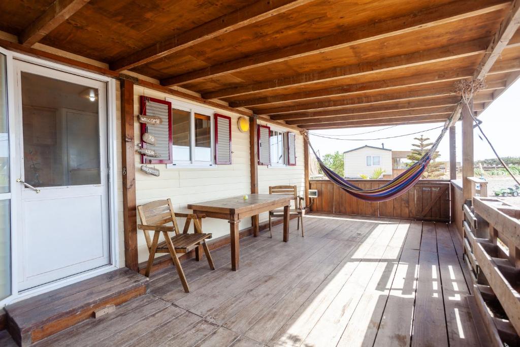 RoqueCowboy Cottage with Sea View的门廊配有木桌、椅子和吊床