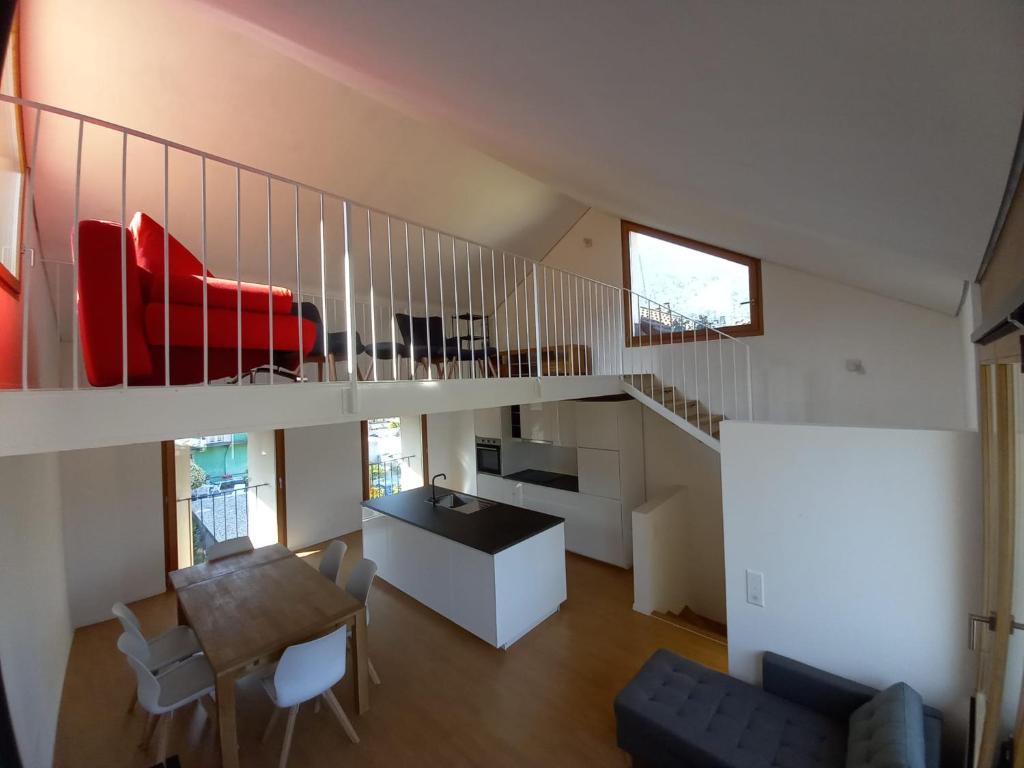 洛索内LA TICINELLA的一间带楼梯和红色沙发的客厅
