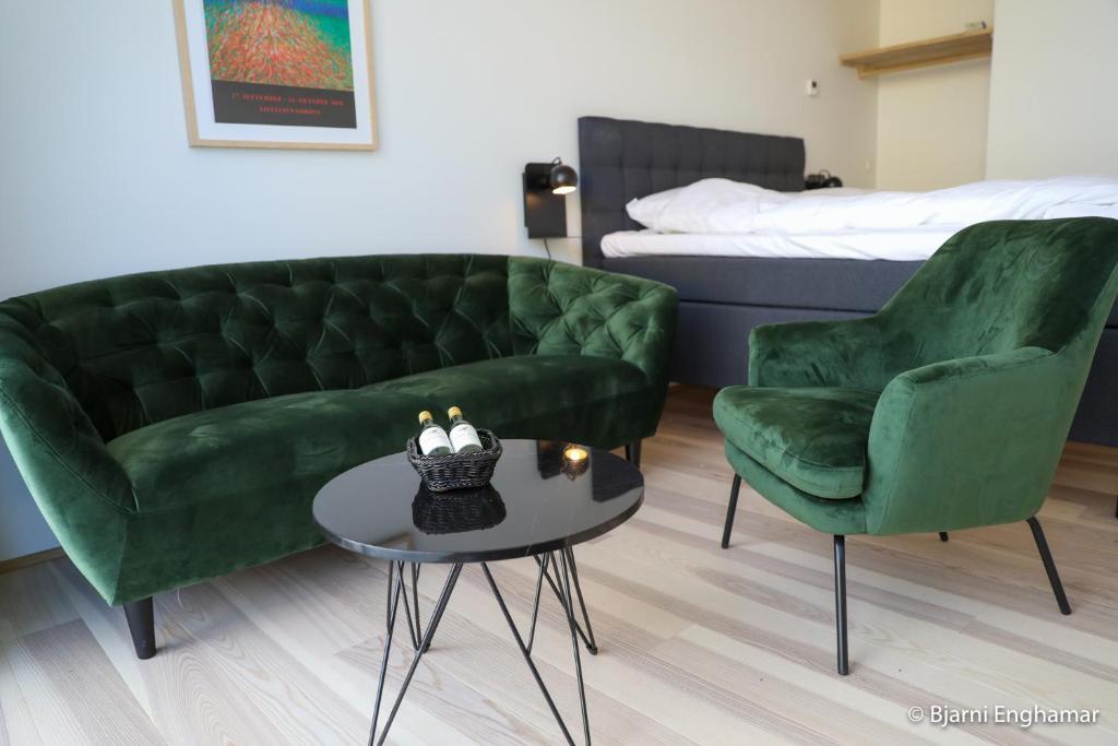SkálavíkMølin Guesthouse的客厅配有沙发、两把椅子和一张桌子