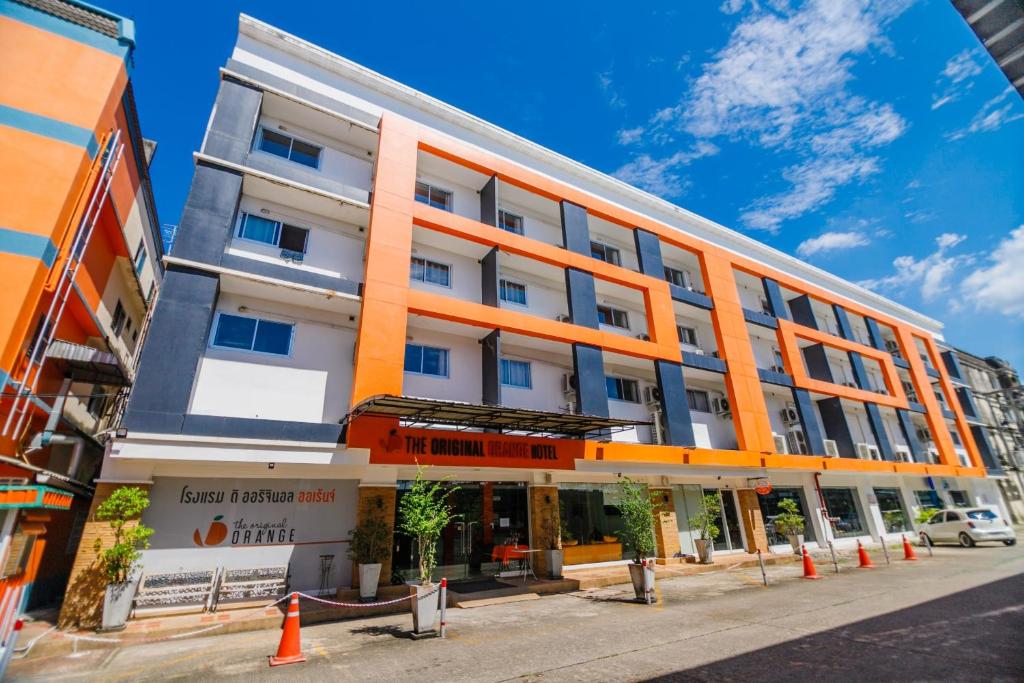 洛坤府橙色原味酒店的一条城市街道上的橙色和白色建筑