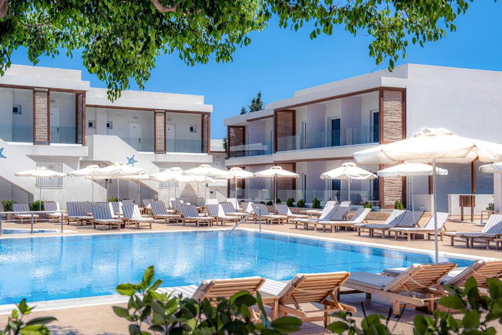古瓦伊Aelius Hotel and Spa的酒店游泳池设有椅子和遮阳伞