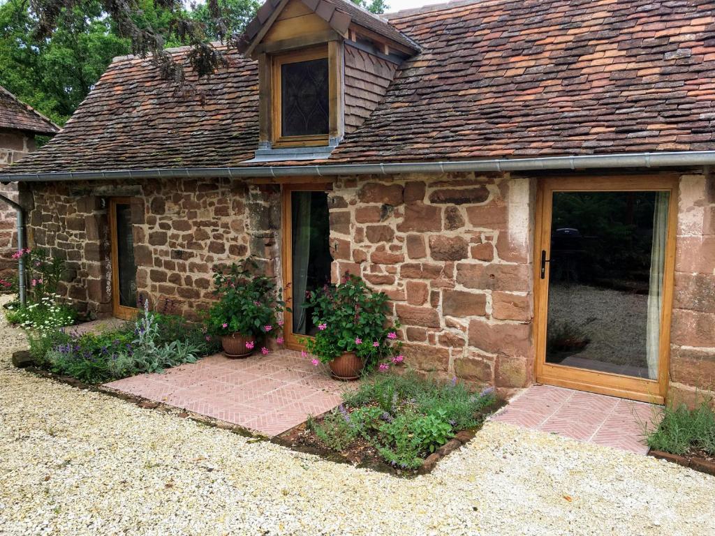 BoisseuilhCountryside tiny house near Chateau de Hautefort的前面有盆栽植物的石头房子