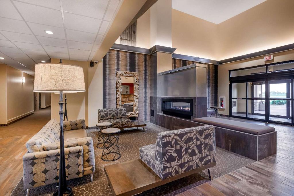 伯灵顿Comfort Suites Burlington的客厅配有两把椅子和壁炉