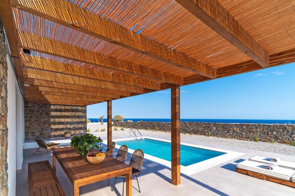 吉奥塔略Terra d'Oro Sea view villa with private pool的一个带木制凉亭和游泳池的庭院
