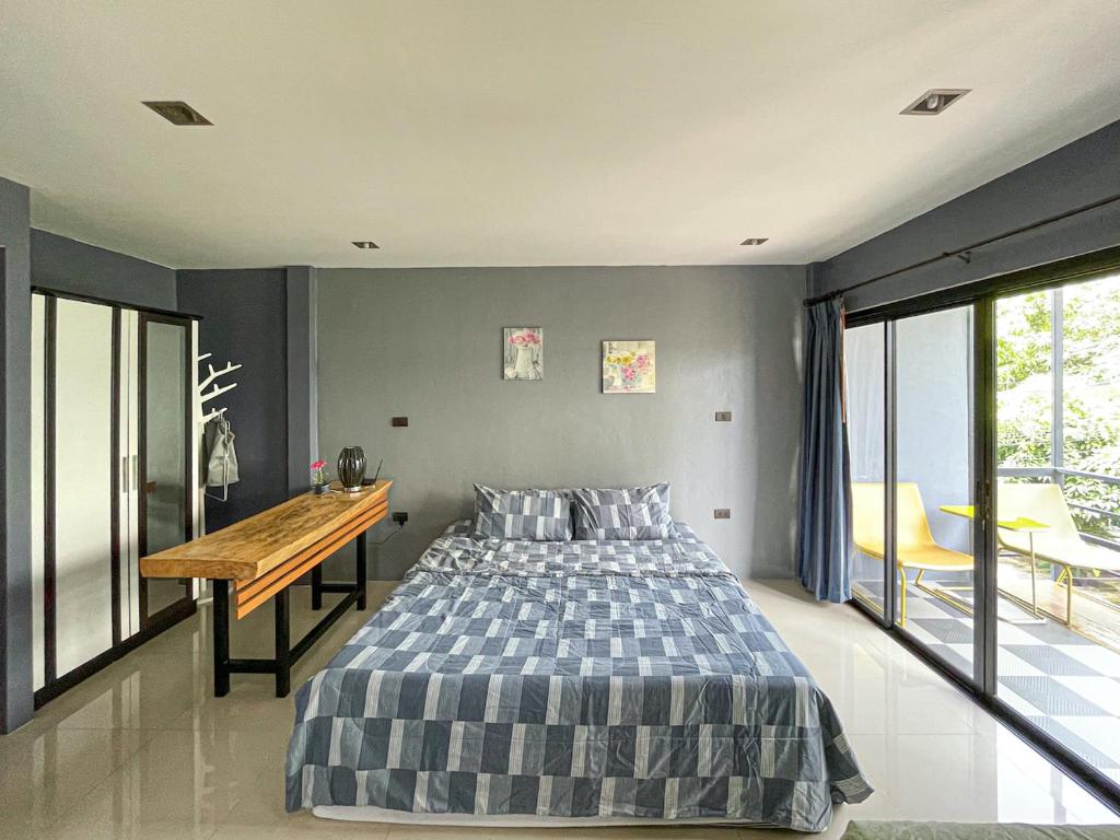 邦涛海滩The Endless Bangtao Residence LOFT 7的一间卧室配有一张床和一张木桌