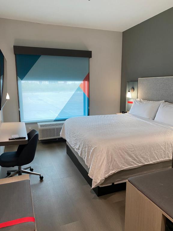 波特兰AVID Hotels Corpus Christi - Portland, an IHG Hotel的酒店客房设有一张床和一个大窗户