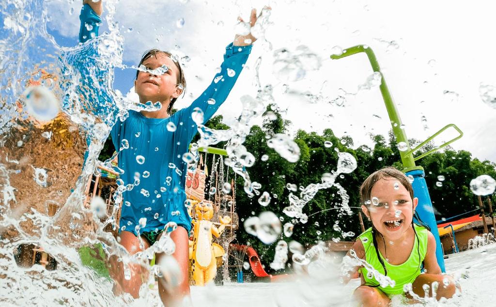 卡达斯诺瓦斯LACQUA com PROMOCOES EM OUTROS PARQUES E DESCONT O的两个孩子在水上公园玩耍
